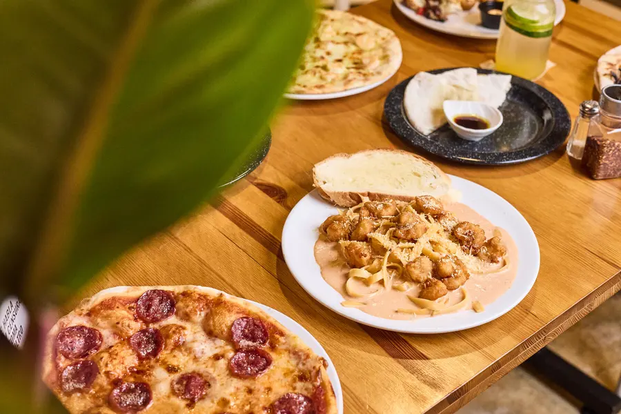 Mesa de VIALETTO con pizza y pasta servidas
